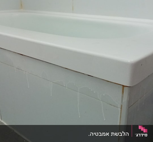 אמבטיה עם חיפוי אריחים לבנים ונזילות מים